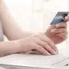 femal holding a credit card and using computer
